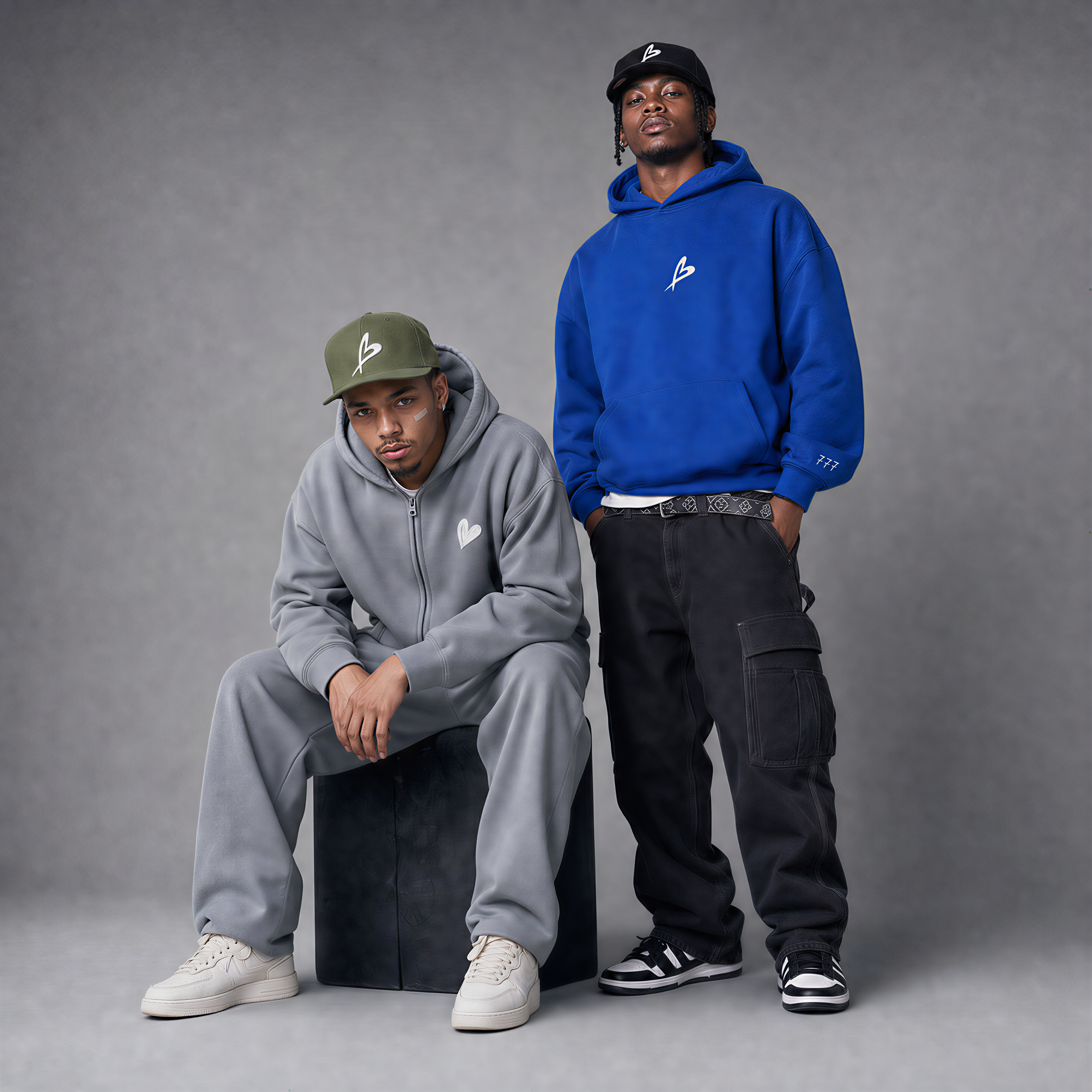 Two individuals wearing hoodies and pants against a gray backgroundslider_item_RYaQGi